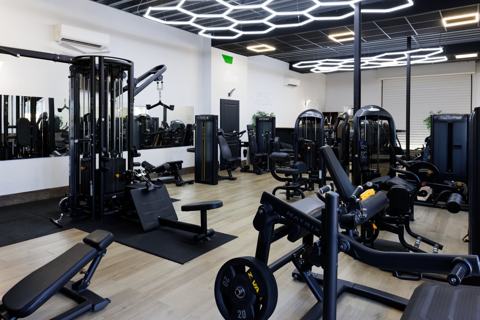 Salle de sport équipée, plafond lumineux et matériel Matrix
